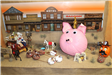 A pumpkin decorated as a piggy bank with coins going in, sitting in an Old West diorama