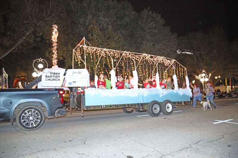 Parade float with a little house made of Christmas lights