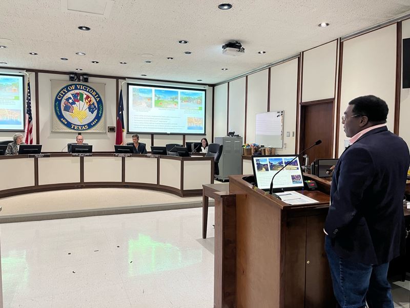 Mike Etienne, at the City Council podium, addresses HFC members seated at the dais.
