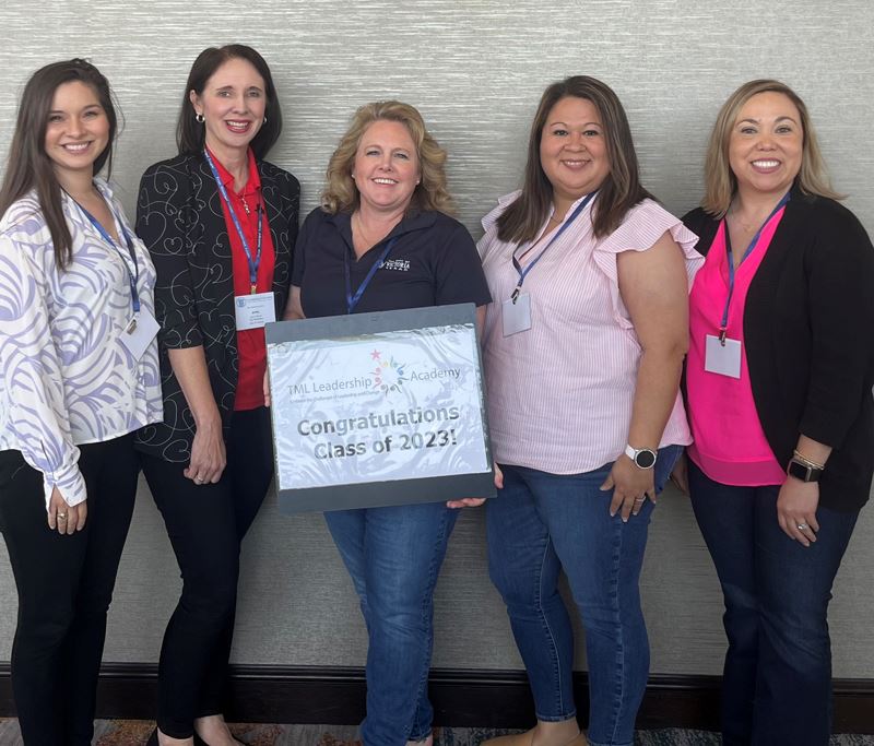Group photo. One woman holds a sign that says TML Leadership Academy. Congratulations Class of 2023.