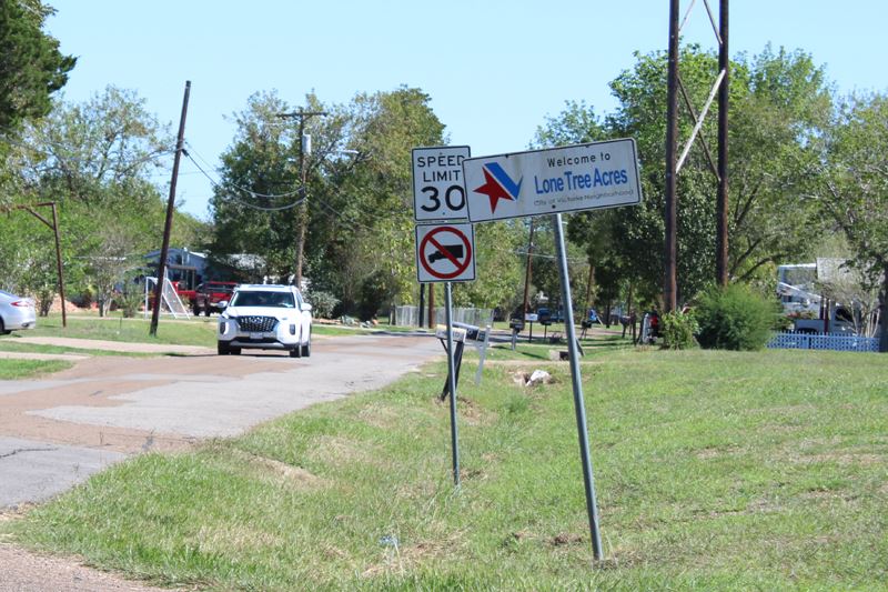 Simple sign at the entrance to a neighborhood reading 