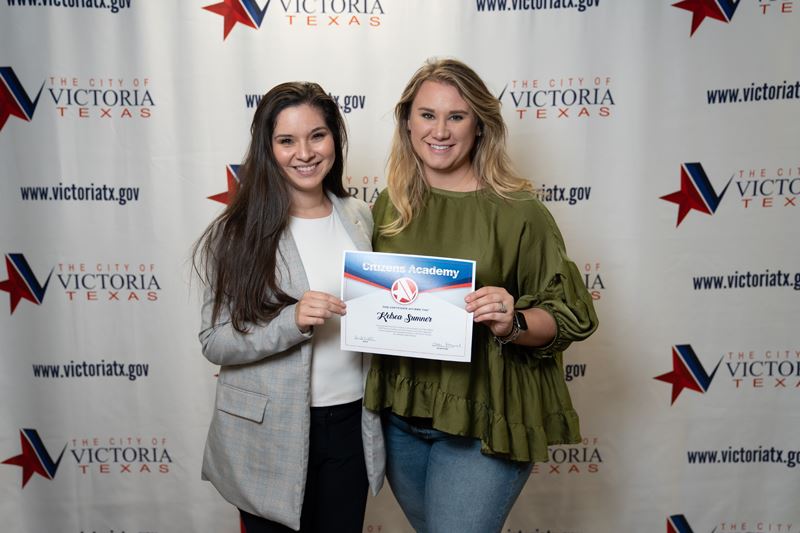 Two women pose for a photo with a Citizens Academy certificate