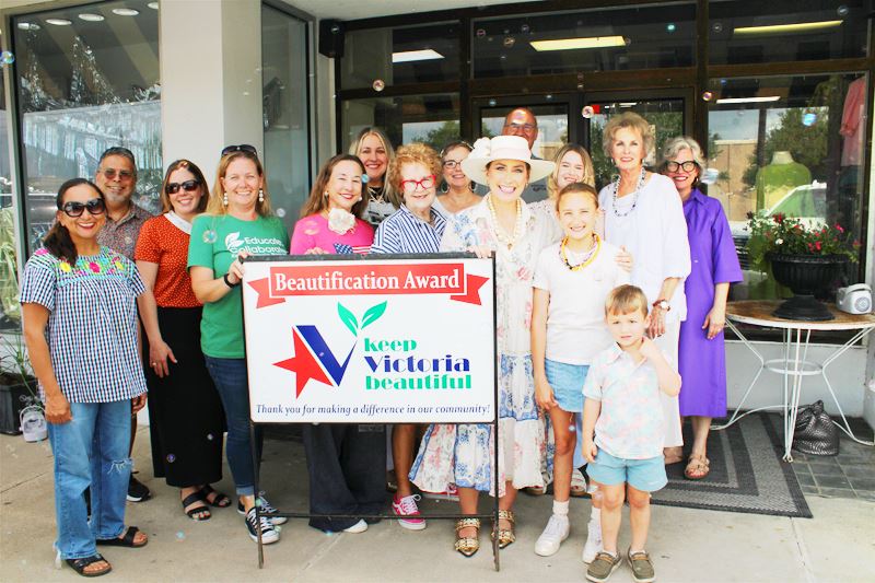 Group photo with KVB sign in front of a storefront