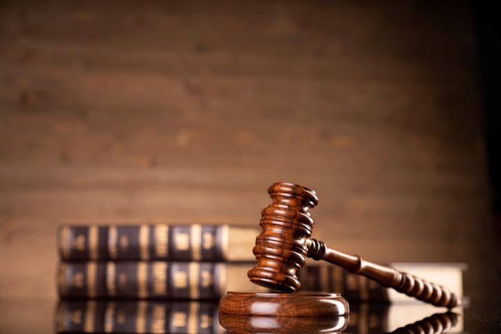 Gavel sitting on a table with three worn volumes in the background