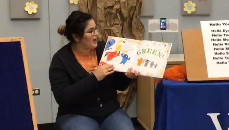 Woman reads aloud from picture book