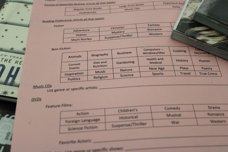 A paper form listing genres of books, CDs and DVDs to be circled according to preference.