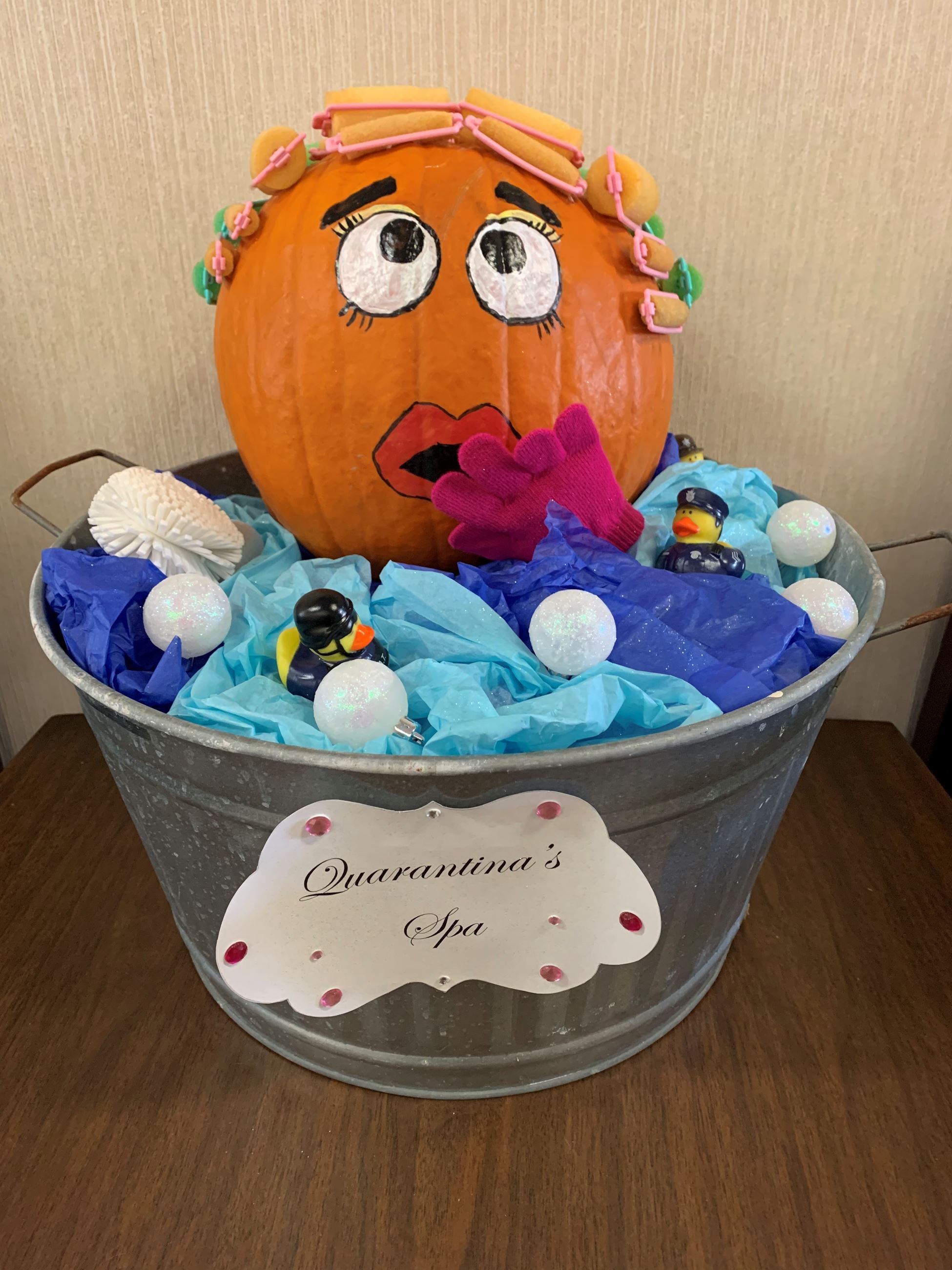 Pumpkin woman sitting in a tub with fake water and bubbles made of golf balls