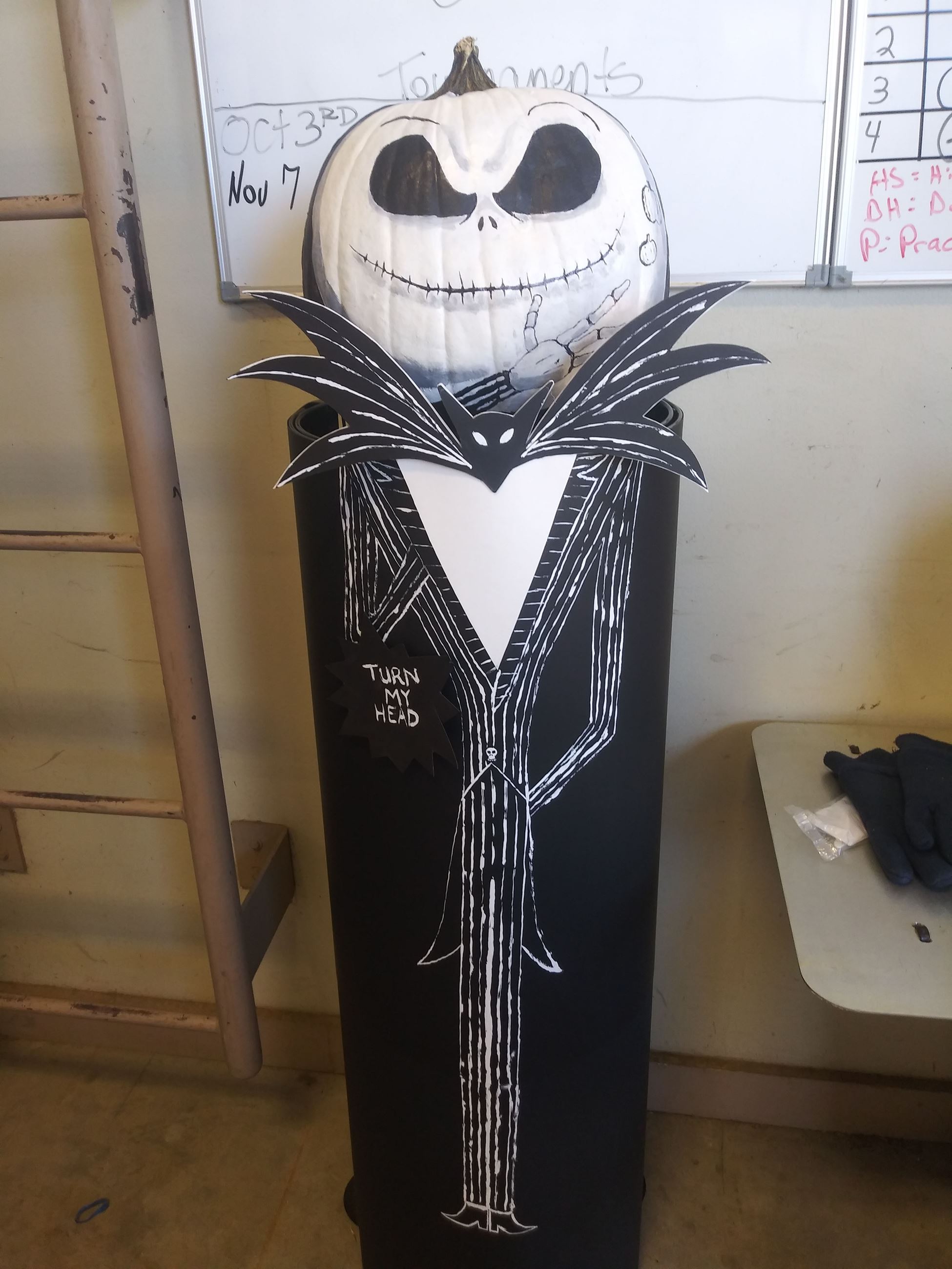 Jack Skellington figure with pumpkin head. Sign reads, 