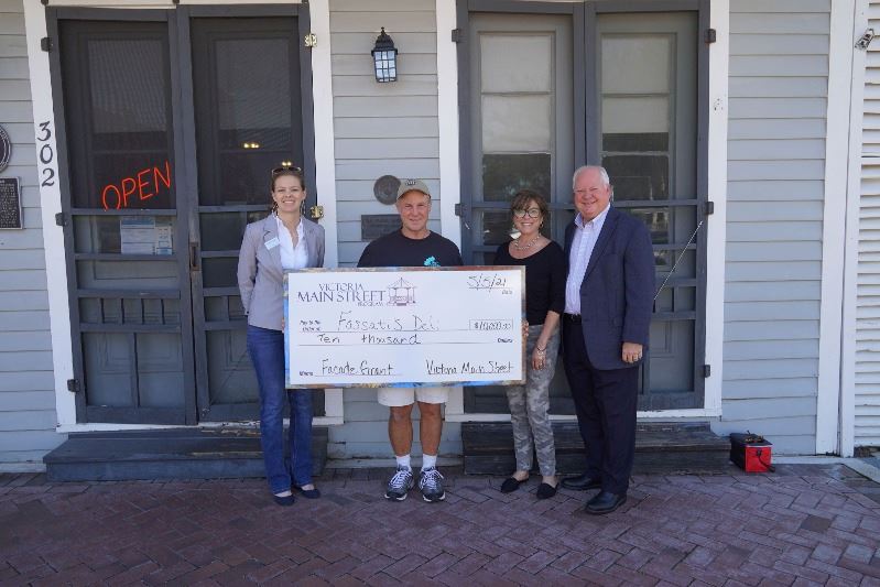 Four people pose with giant check at Fossati's