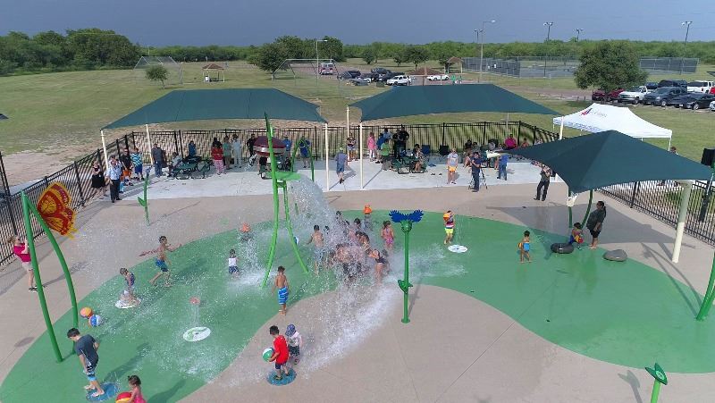Overhead view of kids playing under water features at splash pad