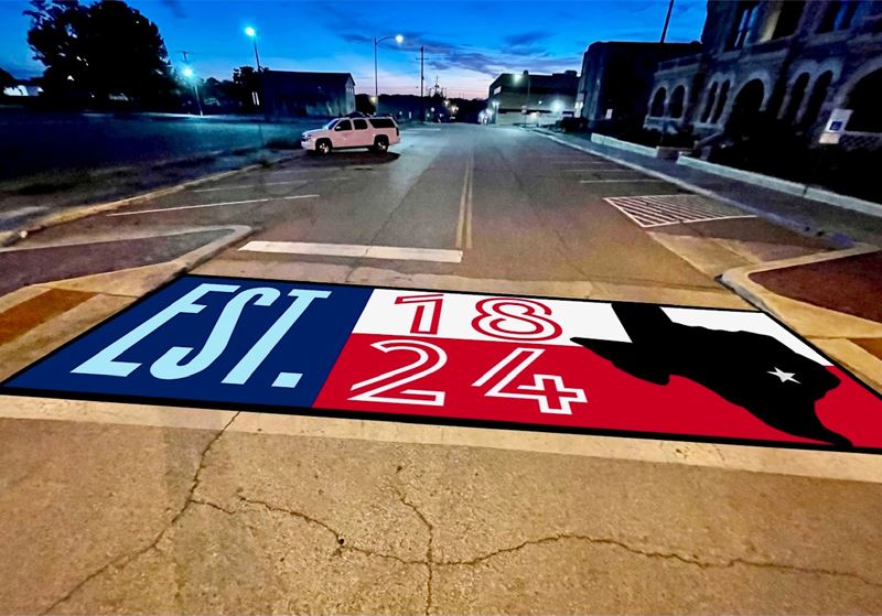 Crosswalk painted with a Texas flag marked Established 1824