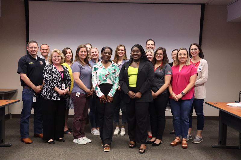 Large group photo in a conference room Opens in new window