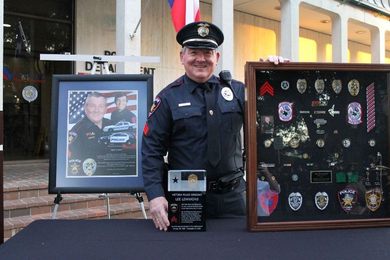 Sergeant Lee Lemmons holds a shadow box at an outdoor ceremony
