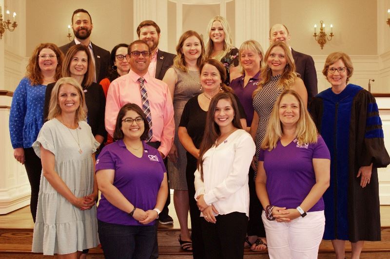 17 adults, including one in academic regalia and 4 in polos with Texas Christian University colors