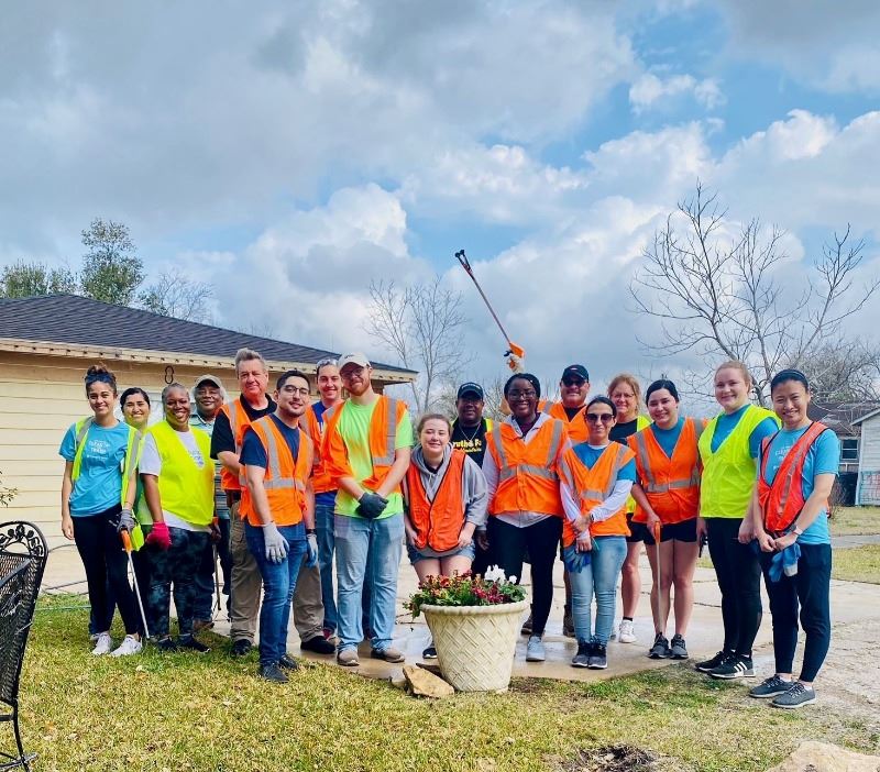 Group photo of 17 volunteers wearing safety vests at a clean up event