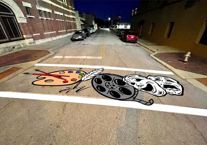 Crosswalk painted with theater masks, a film reel and a painter's palette